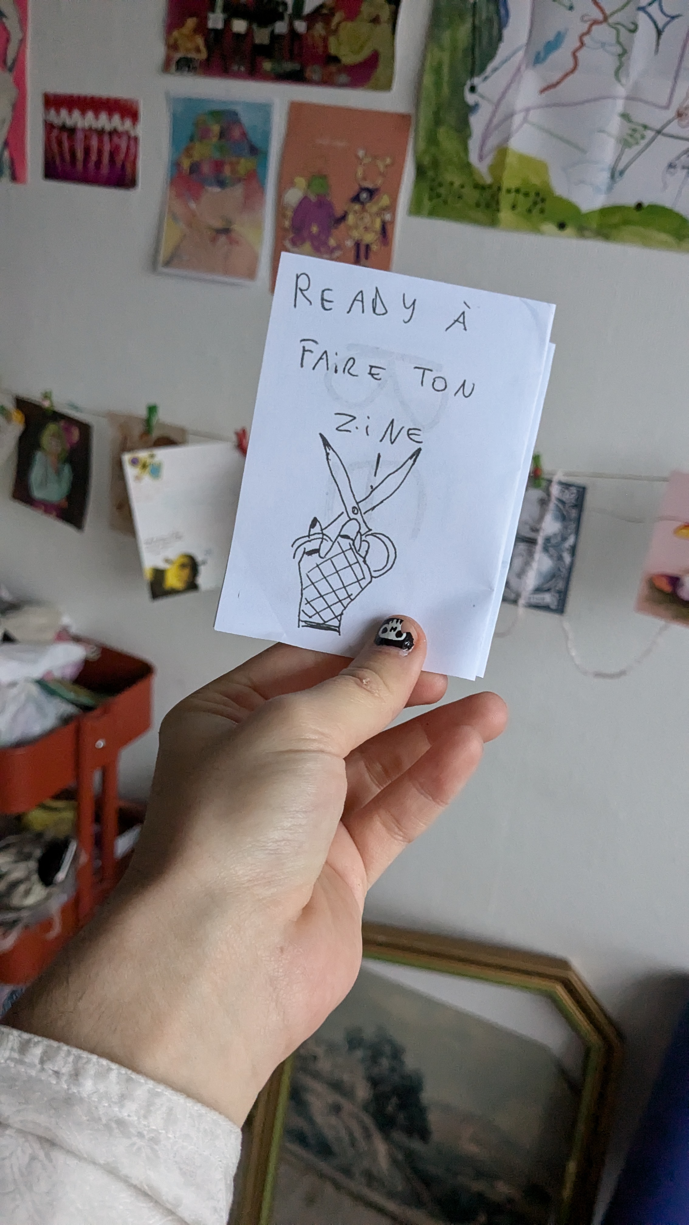 Une main tient un petit zine avec écrit zine tuto dessus